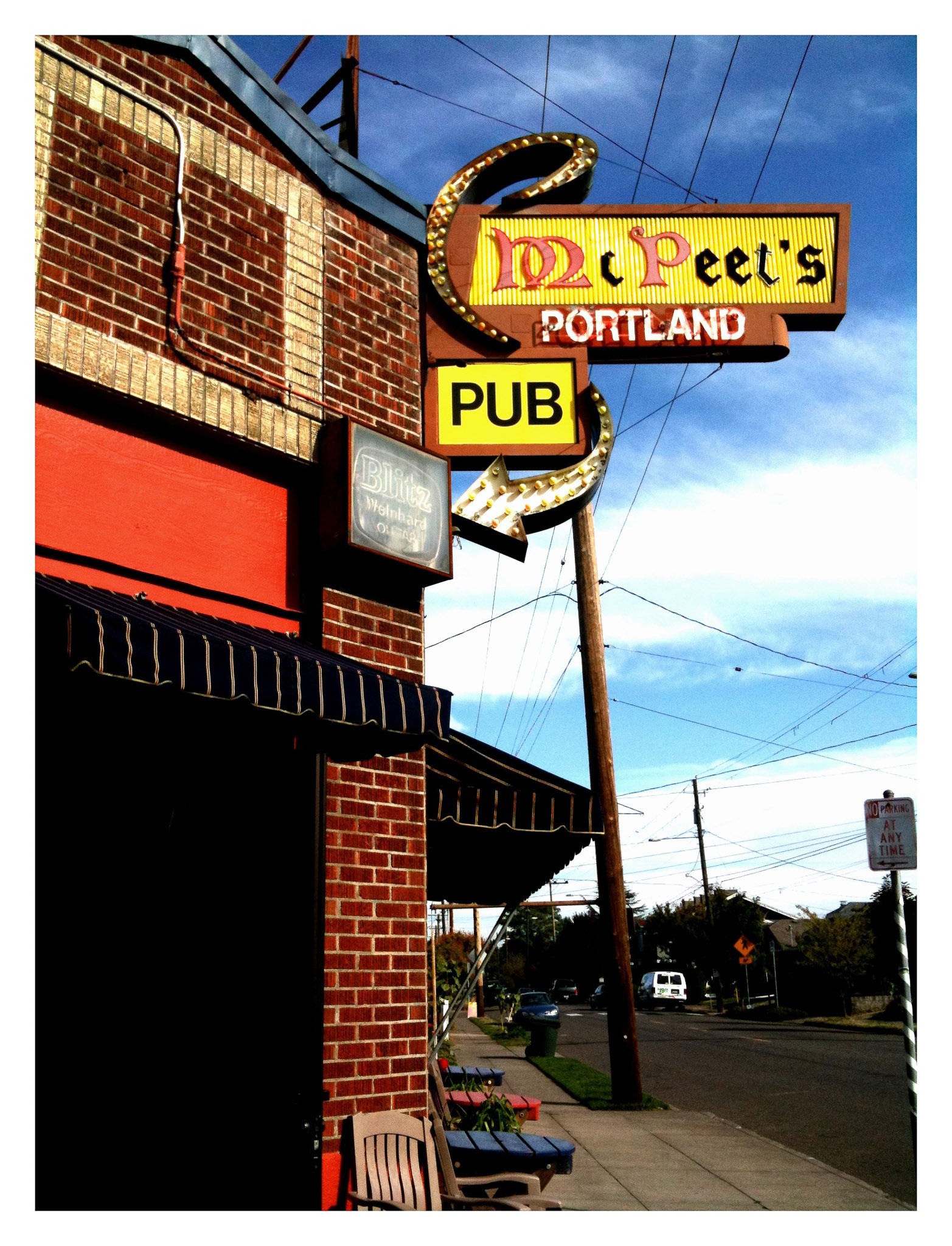 A brick building features a large, retro-style sign for McPeet's Portland Pub on a street corner.