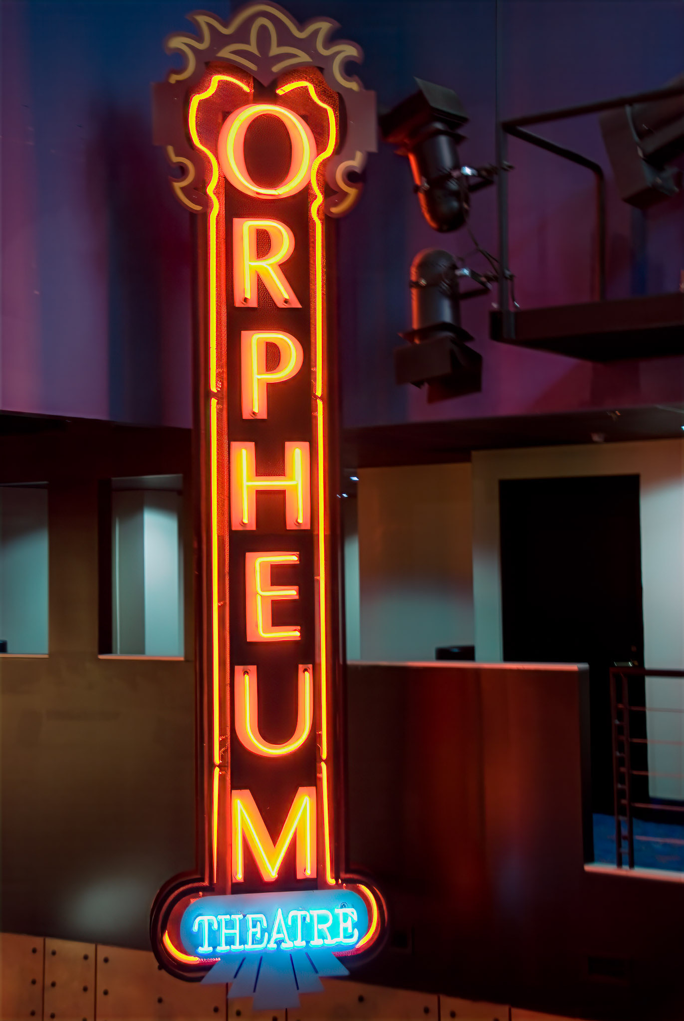 A vertical neon sign displays the words Orpheum Theatre in brightly lit letters.