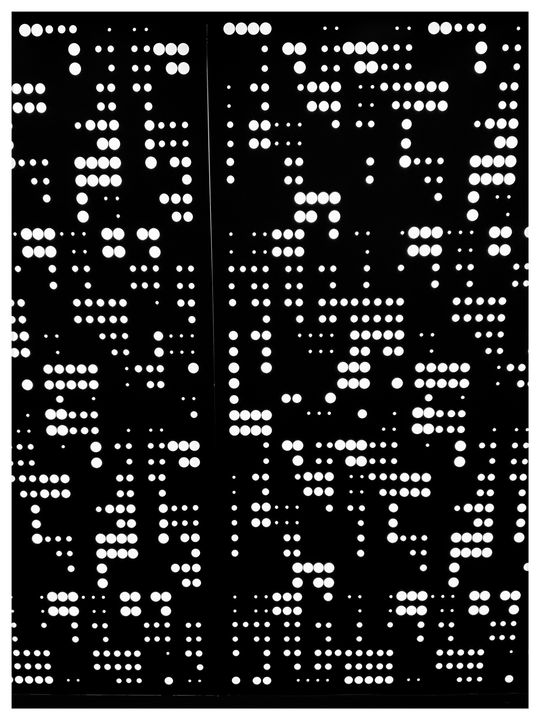 Auto-generated description: A pattern of white dots is arranged on a black background, resembling a punch card.